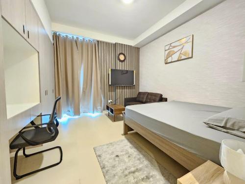 a bedroom with a bed and a couch and a tv at KCA c5- 608 in Abu Dhabi