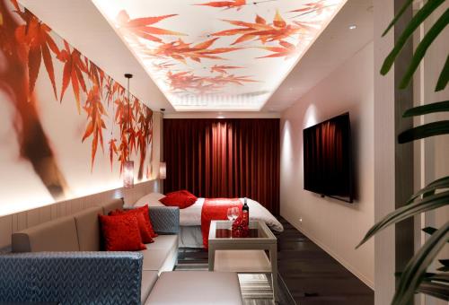 a hotel room with a bed and red pillows at HOTEL 翠 sui -TIMELESS GARDEN- in Koshido