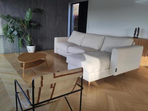a living room with a white couch and a table at La Bergerie de Lives in Namur