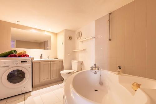une salle de bain avec baignoire et machine à laver dans l'établissement Au Coeur de l'Ecusson - Appartement de caractère, à Montpellier