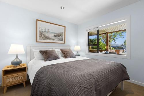 a bedroom with a large bed and a window at Wanaka Tree On Your Doorstep! in Wanaka