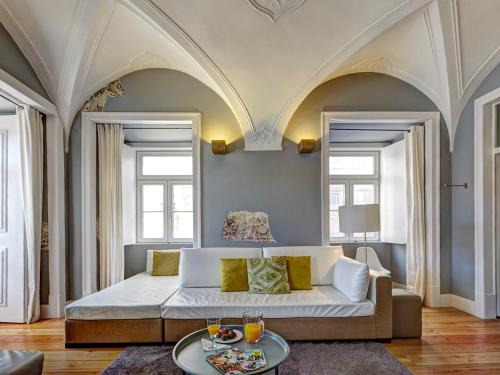 a living room with a bed and two windows at Sonel Investe Figueira Boutique Apartment by Get Your Stay in Lisbon