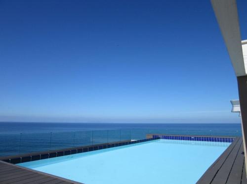 a swimming pool with the ocean in the background at Feli's Apartment in Castelsardo