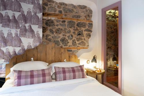 a bedroom with a bed with two pillows on it at Robolo Boutique Hotel by H&T in Litochoro