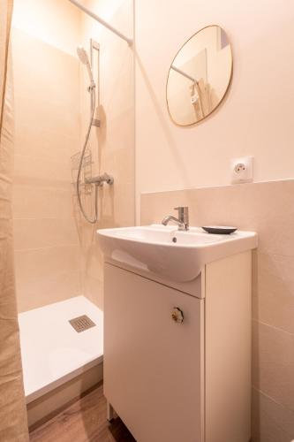 une salle de bain blanche avec un lavabo et une douche dans l'établissement Cosy Rouen - A 10min du métro, à Rouen