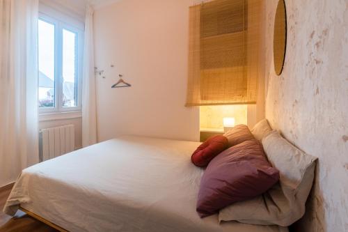 une chambre avec un lit avec deux oreillers dessus dans l'établissement Cosy Rouen - A 10min du métro, à Rouen