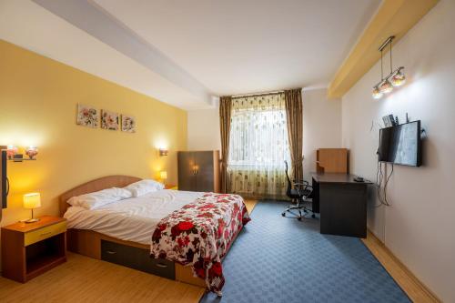 a hotel room with a bed and a television at Casa Rehner in Sighişoara