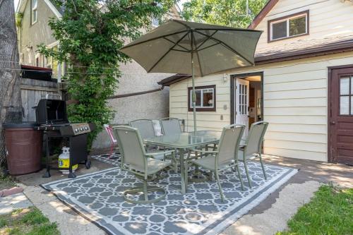 a patio with a table and chairs and an umbrella at Raptor Retreat Family in Drumheller