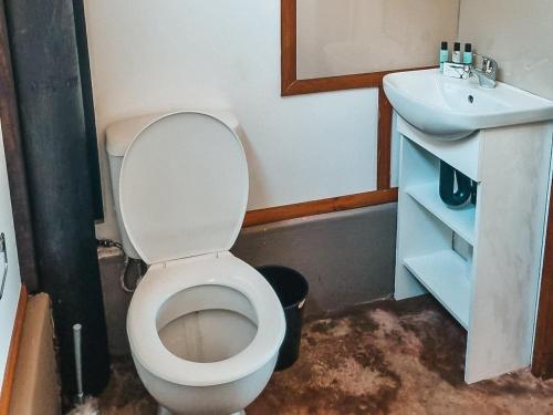 a bathroom with a white toilet and a sink at Pongola Poort Safari Camp in Bethel