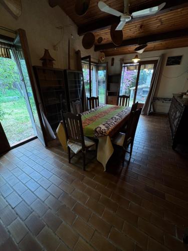 une salle à manger avec une table, des chaises et des fenêtres dans l'établissement Charmante villa avec jardin proche plages - Grau d'Agde, au Grau-dʼAgde
