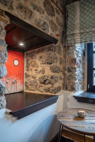 a room with a table and a stone wall at Robolo Boutique Hotel by H&T in Litochoro
