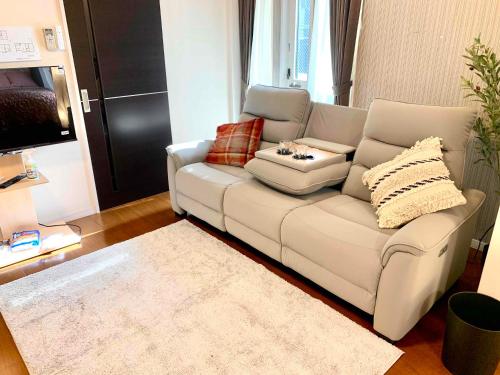 a white couch in a living room with a rug at Monzennakacho Royal Residence in Tokyo
