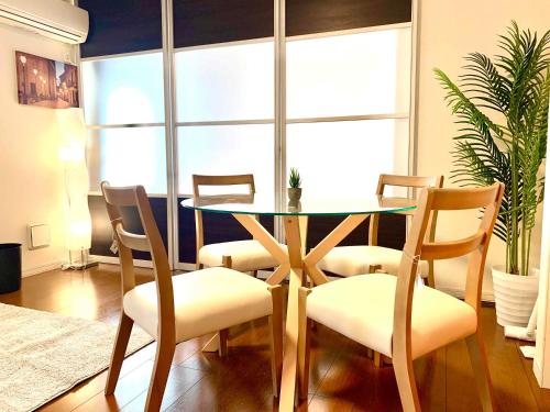 a dining room with a glass table and chairs at Monzennakacho Royal Residence in Tokyo