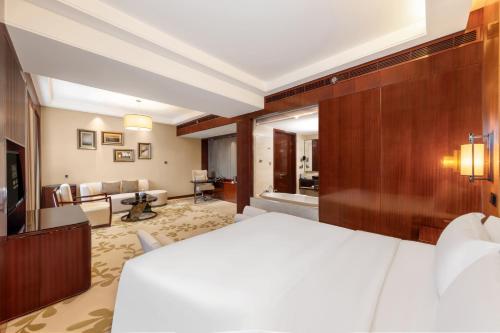 a hotel room with a bed and a living room at Enlux Hotel in Jinan