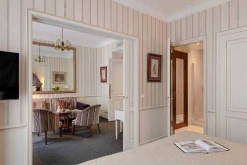 a living room with a table and a dining room at Hôtel Napoleon Paris in Paris