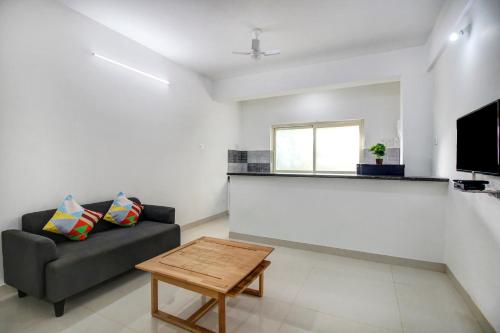 a living room with a couch and a table at Hotel O Muktesh Chandra in Goa