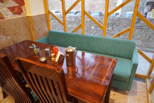 a table and a green couch in a restaurant at Hotel The Royal Barbariq in Khātu