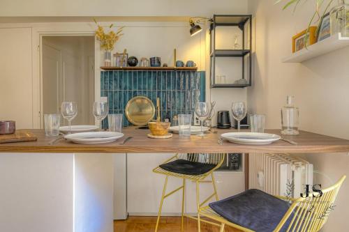 une table avec des verres et des chaises dans une pièce dans l'établissement La Loge du Gardien - T2 Proche Fourvière, à Lyon