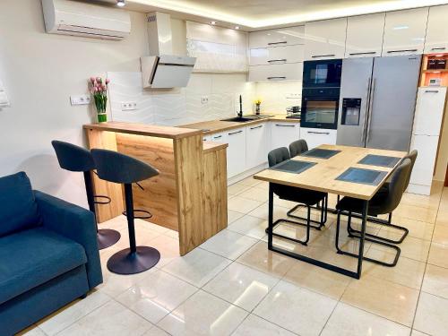 a kitchen with a table and a blue couch at Mese Panzió Zalakaros in Zalakaros