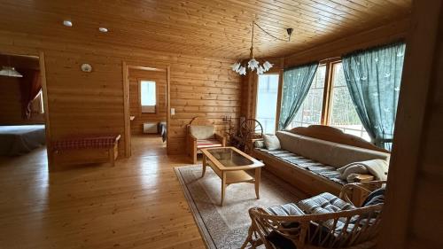 ein Wohnzimmer mit einem Sofa in einem Holzhaus in der Unterkunft Cozy Cottage in Kerimaa in Savonlinna