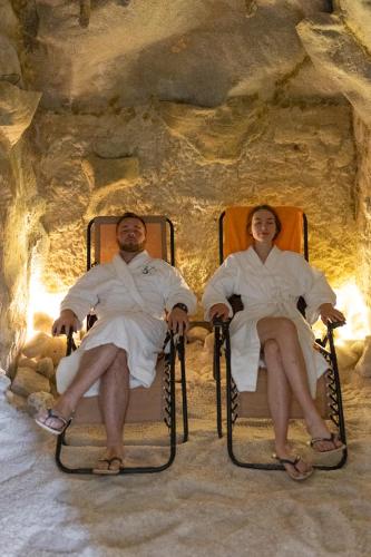 a man and woman sitting in chairs in a cave at Kurhotel Brussel in Františkovy Lázně