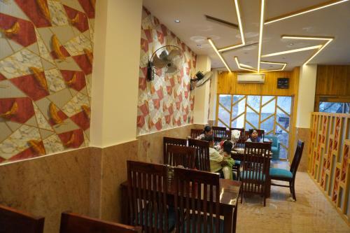 a restaurant with people sitting in chairs in a room at Hotel The Royal Barbariq in Khātu