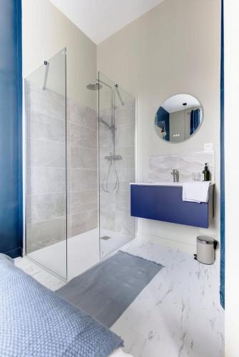 une salle de bain avec un lavabo bleu et une douche dans l'établissement Appartement Laval Centre, à Laval