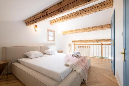 Cette chambre comprend un lit avec des draps blancs et du parquet. dans l'établissement 2 Chambres, proche des plages, parking, à Fréjus