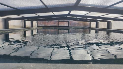 une piscine d'eau vide dans un bâtiment dans l'établissement Maison des Grézels, à Saint-Cybranet