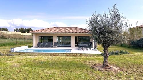 une maison avec une piscine dans une cour dans l'établissement Villa moderne Giens proche plage piscine climatisation Wifi By HC, à Hyères