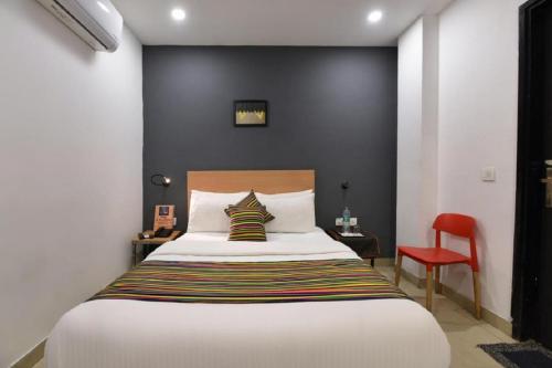 a bedroom with a large bed and a red chair at Hotel City Empire at Janakpuri " Couple Friendly" in New Delhi