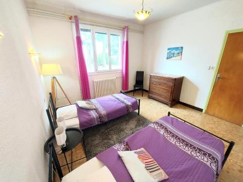 Cette chambre comprend 2 lits, une commode et une fenêtre. dans l'établissement 120m2 rdc 2km mer soleil catalan 2ch wifi 4pers ok chéques vacances animaux, à Latour-Bas-Elne