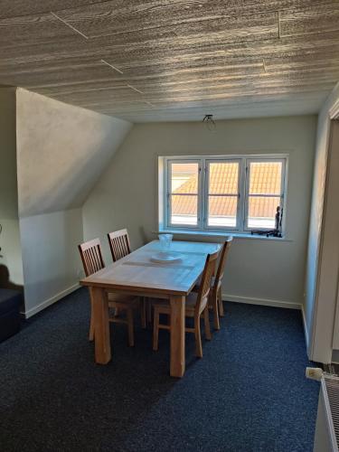 a dining room with a wooden table and chairs at JP Apartment Floor 2 in Grindsted