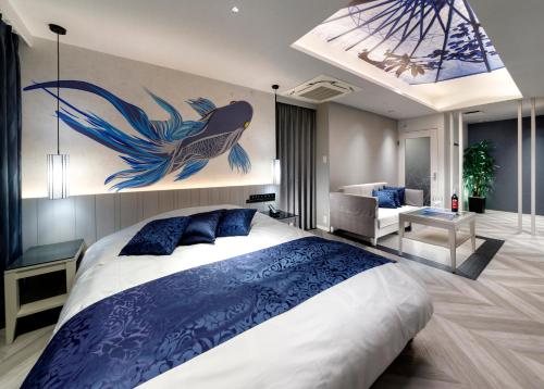 a bedroom with a large bed with a painting on the wall at HOTEL 翠 sui -TIMELESS GARDEN- in Koshido