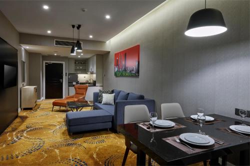 a living room with a blue couch and a table at Pullman Kuala Lumpur City Centre Hotel & Residences in Kuala Lumpur
