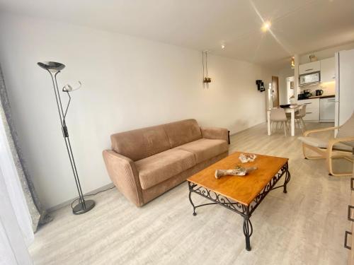 un salon avec un canapé et une table basse dans l'établissement LE BOUCANET - APPARTEMENT CLIMATISÉ ENTIEREMENT RÉNOVÉ POUR 4 PERSONNES AVEC PARKING PRIVATIF, au Grau-du-Roi