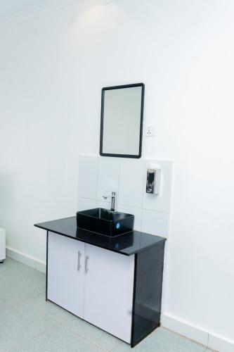 un bancone del bagno con lavandino e specchio di Make Good Apartment a Kigali