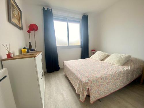 une chambre avec un lit et une fenêtre dans l'établissement LE BOUCANET - APPARTEMENT CLIMATISÉ ENTIEREMENT RÉNOVÉ POUR 4 PERSONNES AVEC PARKING PRIVATIF, au Grau-du-Roi