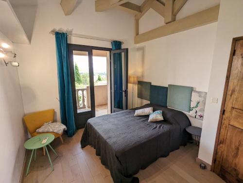 une chambre avec un lit et une grande fenêtre dans l'établissement Villa Olivera, à Saint-Sernin