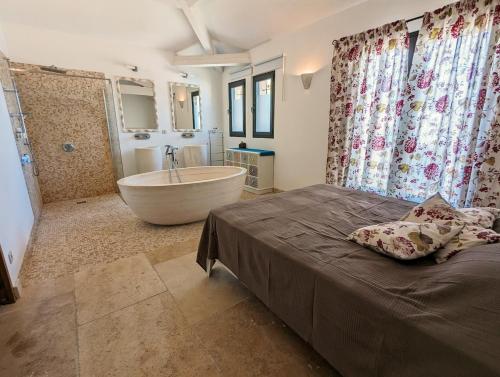 une chambre avec une baignoire, un lit et un lavabo dans l'établissement Villa Olivera, à Saint-Sernin