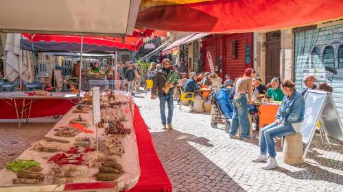 a crowd of people walking around a market with food at Au coeur de la vieille ville, Chambre privée indépendante in Sommières