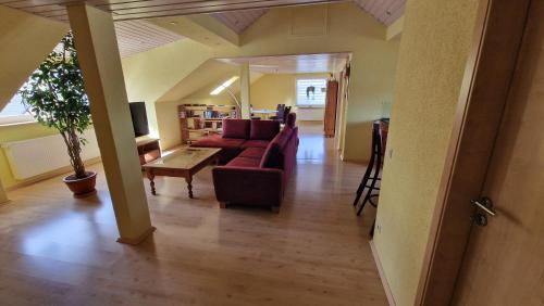 a living room with a red couch and a table at Ferienwohnung Wiesental II, Wiesentalstrasse 1, 89331 Burgau in Burgau