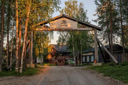 a welcome sign to a cabin on a dirt road at Wilderness Hotel Nellim & Igloos in Inari