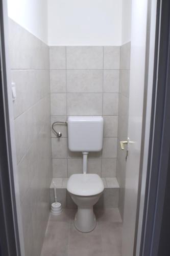 a bathroom with a white toilet in a stall at Hőforrás Hotel in Gyula