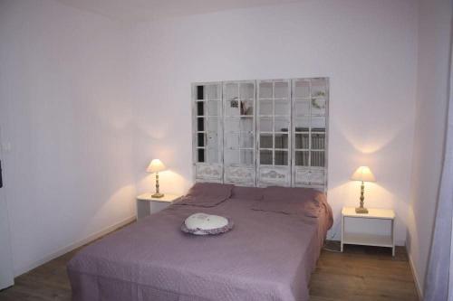 une chambre avec un lit avec deux tables et deux lampes dans l'établissement La Bastide de Marie, à Saint-André-de-Roquelongue