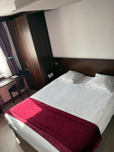 a bedroom with a large bed with a red blanket at Cottage Logis Hôtel - Restaurant in Dudelange