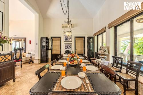 a dining room with a long table and chairs at 5bhk Luxurious Heritage Villa La Bougainvillea with Pvt Pool, Bathtub, BBQ at Porvorim in Porvorim