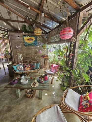 a living room with a table and chairs and plants at Kot Nou - Kwizine Mama Manze Lakaz in Mahébourg