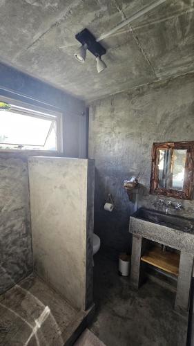 a bathroom with a sink and a mirror at Kot Nou - Kwizine Mama Manze Lakaz in Mahébourg