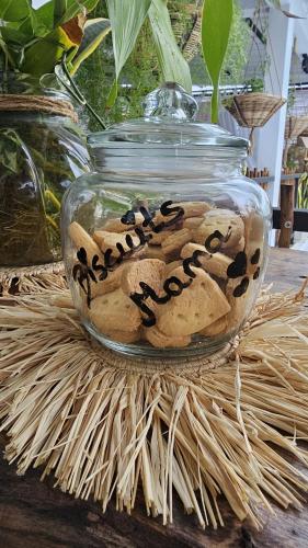 a glass jar filled with cookies on top of a table at Kot Nou - Kwizine Mama Manze Lakaz in Mahébourg